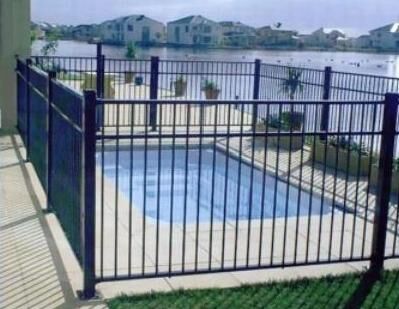 Dark aluminium pool fence around a pool near the water