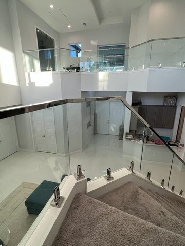 Frameless glass balustrade on spigots around an internal staircase void