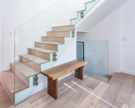 Glass fixed to the side of a staircase with round standoffs